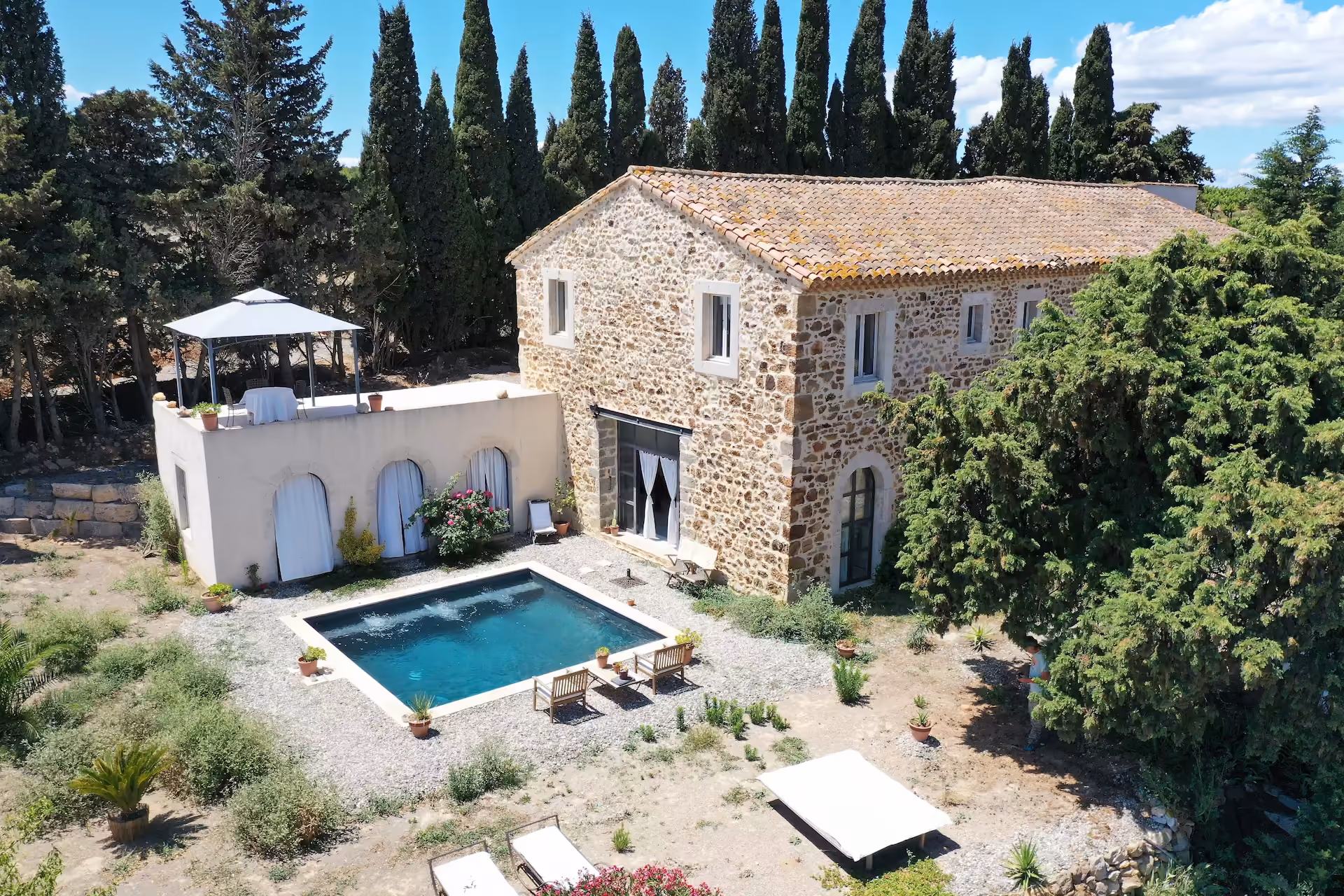 Vue aérienne du Domaine Conscience, de sa maison en pierre et de son jardin arboré